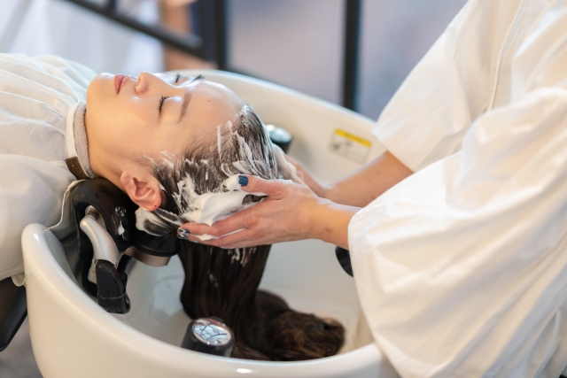 お客様にシャンプーをする美容師